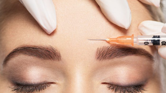 Botox being injected into the forehead.